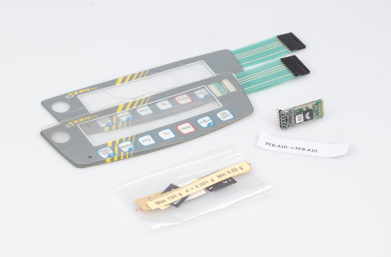 Bluetooth Datenschnittstellen Set auf weißem Hintergrund. Das Set besteht aus eine Leitplatte, zwei Aufkleber für die Anzeige mit Kabel und Zubehör.